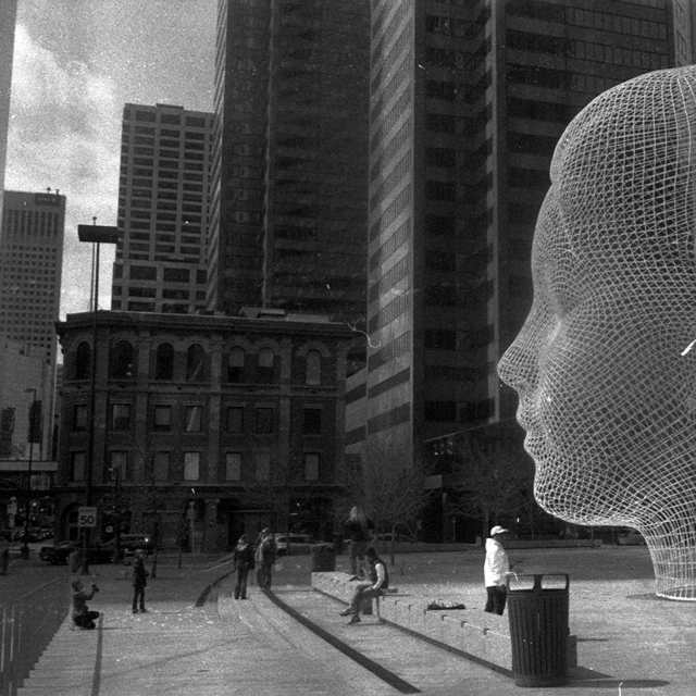 A black and white photo of a statue of a head facing left